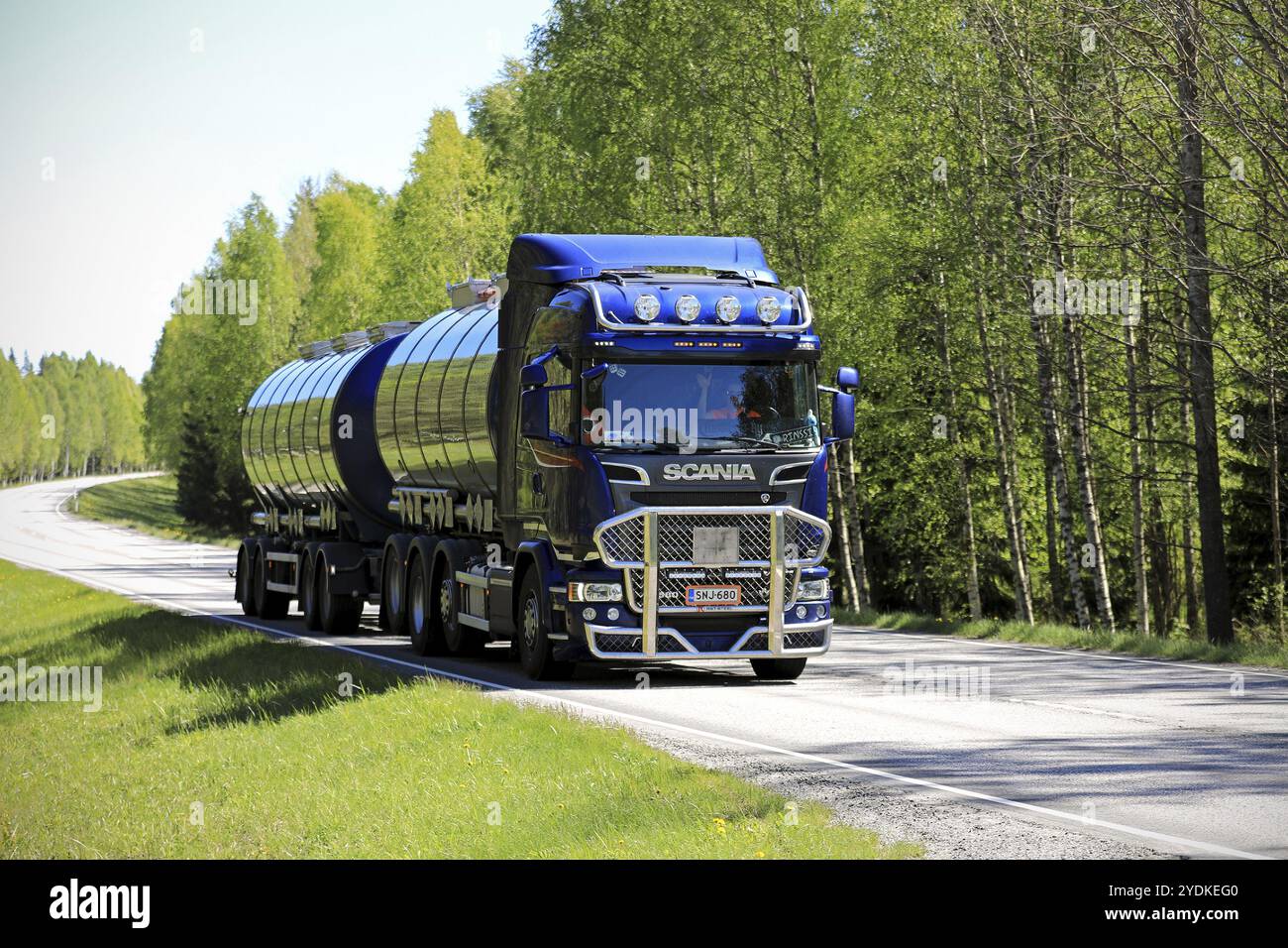 TENHOLA, FINLANDE, 4 JUIN 2017 : camion-citerne bleu foncé SCANIA R580 avec barre de taureau de Tomppa Tuomisto Ky se déplace le long de l'autoroute dans la lumière et l'ombre d'une rura Banque D'Images