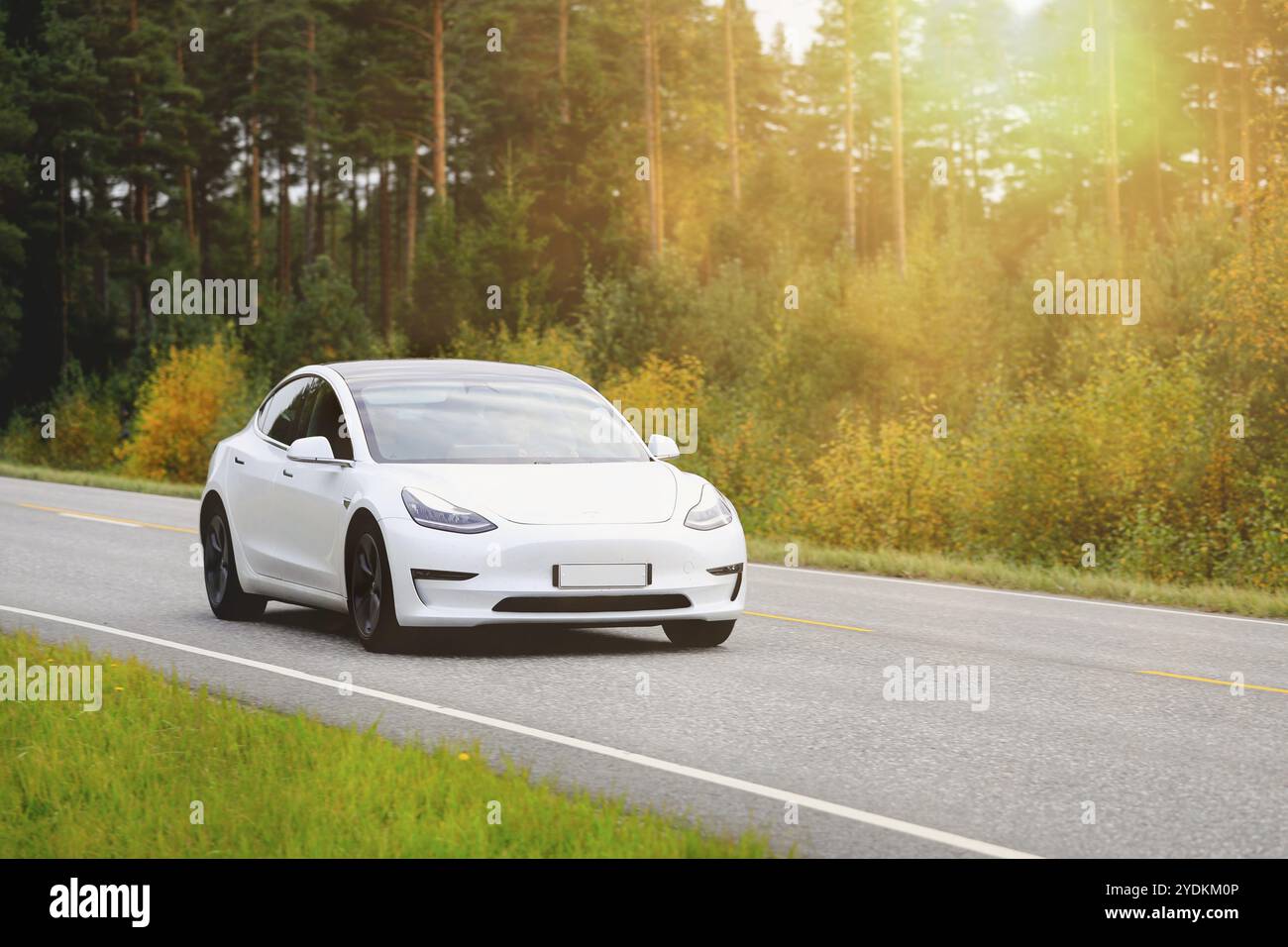 White Tesla Model 3 voiture électrique sur l'autoroute rurale dans la lumière de l'heure d'or de l'automne. Salo, Finlande. 25 septembre 2020 Banque D'Images