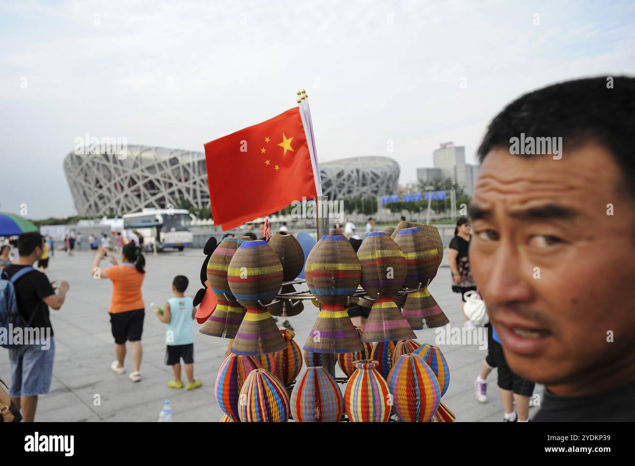 05.08.2012, Pékin, Chine, Asie, touristes près d'un stand de souvenirs avec le drapeau national chinois devant le stade national, qui est également appelé Bir Banque D'Images