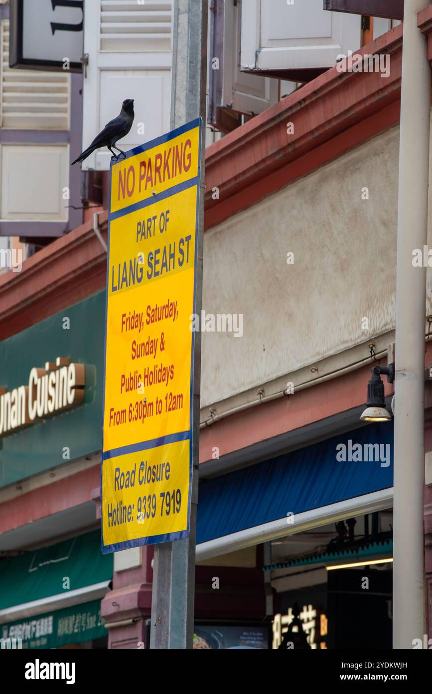 Un panneau de stationnement qui permet de dégager la rue de 18h30 à 12h00 à Liang Seah Street, Singapour pour permettre le service de table des repas de rue Banque D'Images