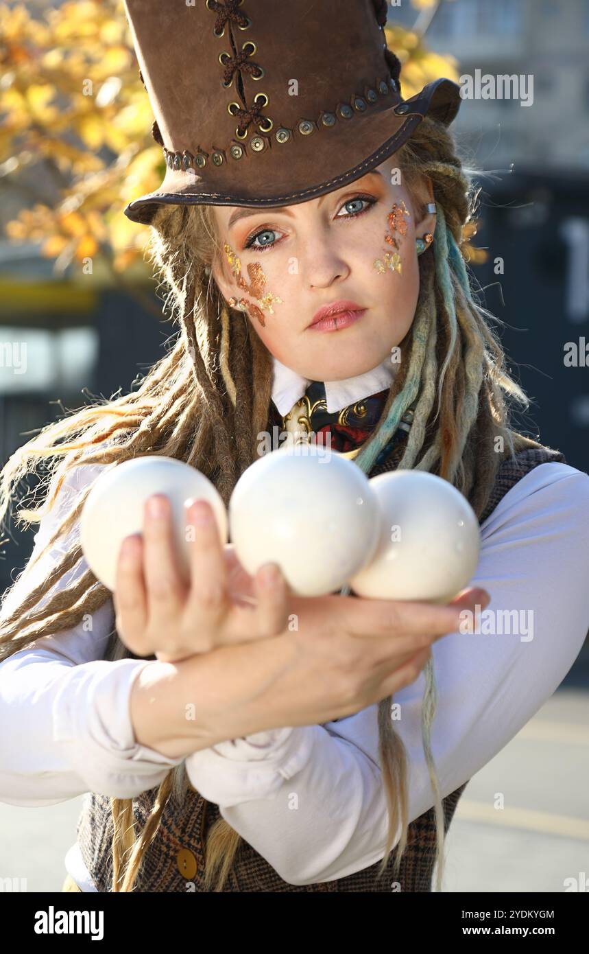 Portrait de jeune femme élégante avec robe de fantaisie et maquillage avec des boules blanches Banque D'Images