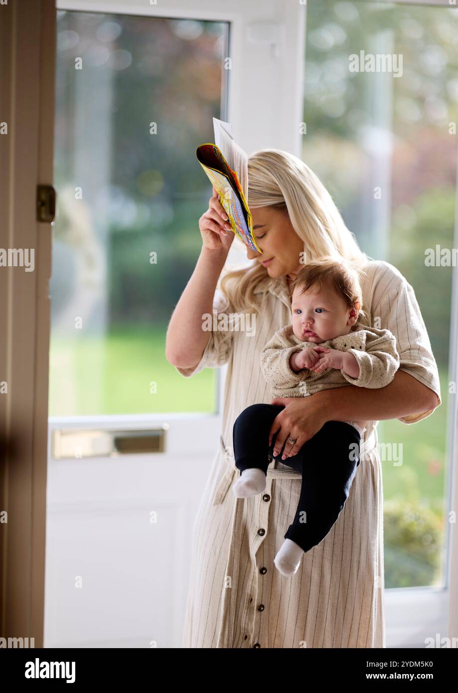 Mère et bébé ramassant le poteau de la porte d'entrée Banque D'Images