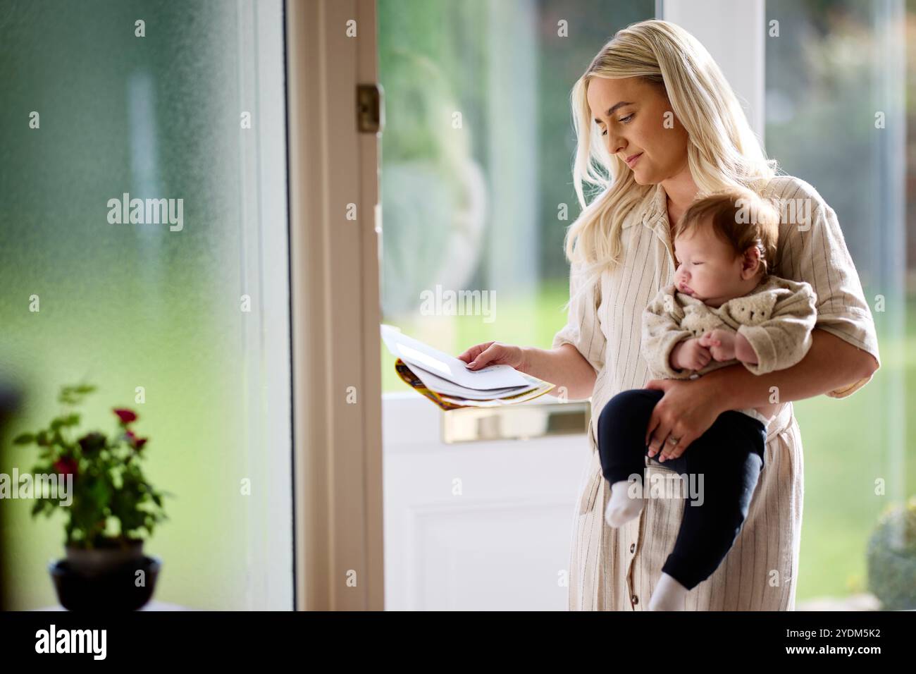 Mère et bébé ramassant le poteau de la porte d'entrée Banque D'Images