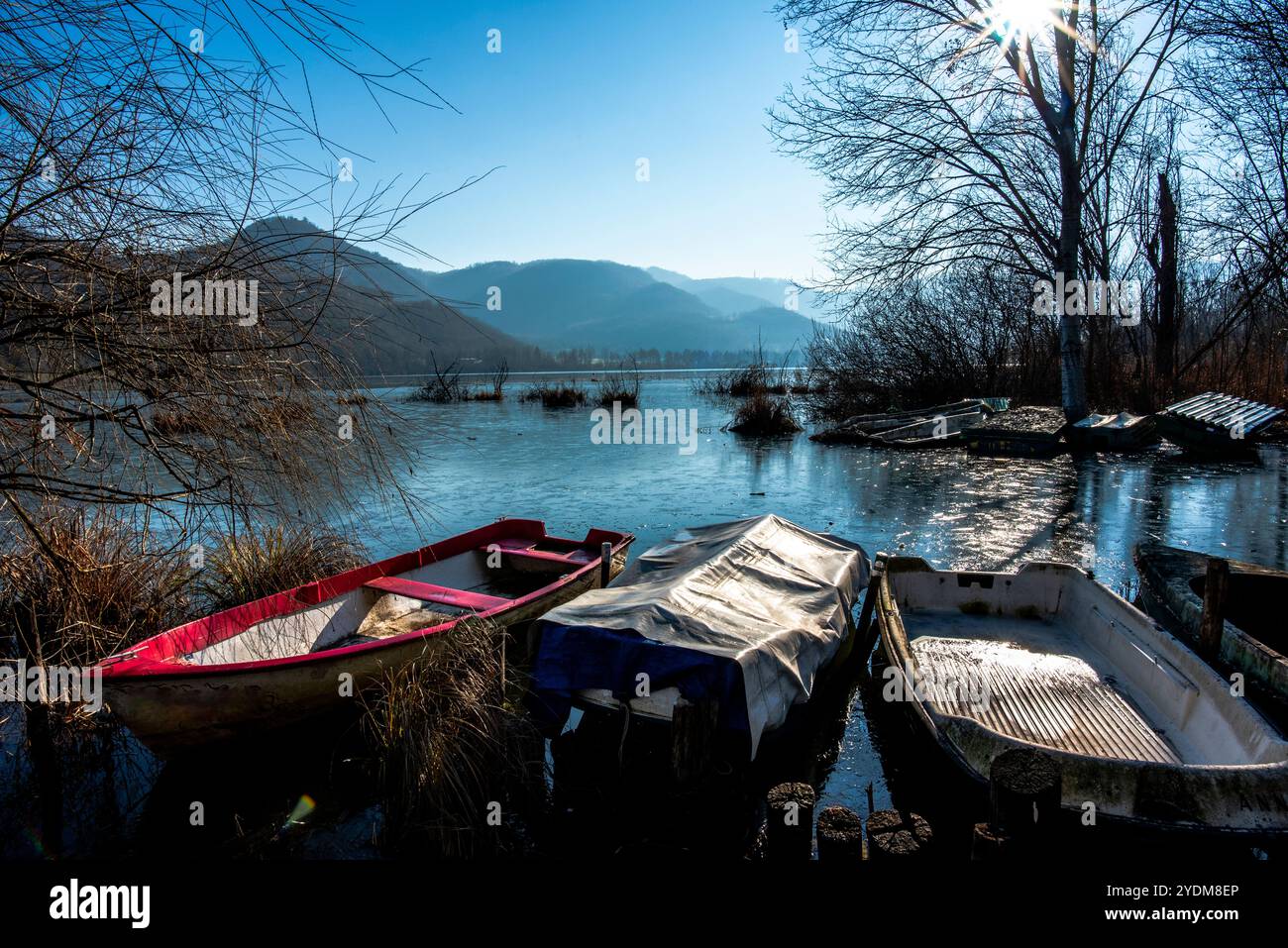 Gros plan de parties de petits bateaux de pêche abandonnés et couverts de mousse dans les eaux gelées du lac Fimon à Vicence Banque D'Images