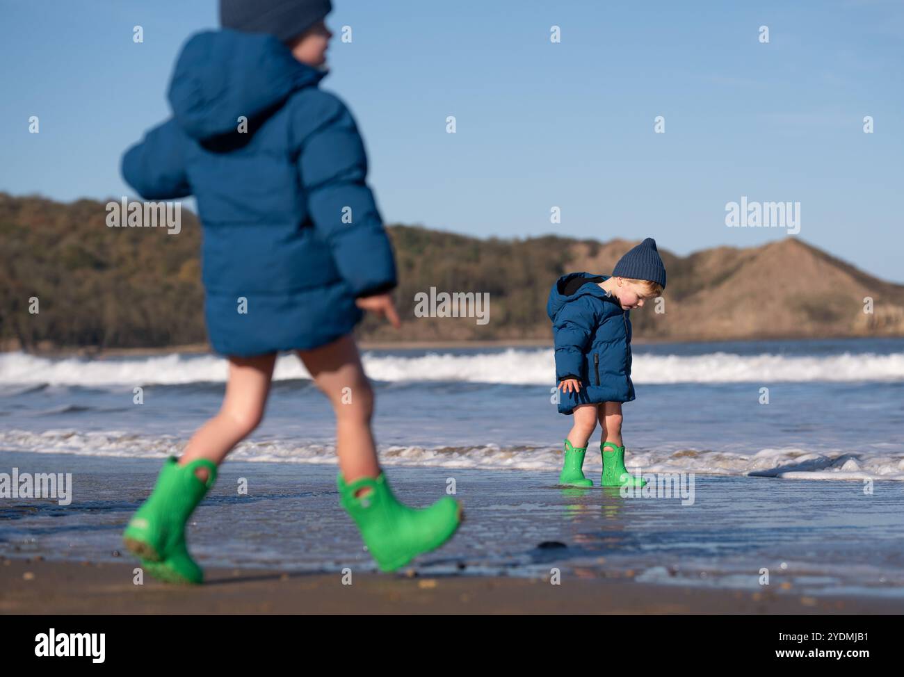 (De gauche à droite) les frères Rudy, trois ans, et Billy, deux ans, (noms de famille non donnés) jouent dans la mer par une froide journée ensoleillée à Cayton Bay à Scarborough, dans le Yorkshire du Nord. Date de la photo : dimanche 27 octobre 2024. Banque D'Images