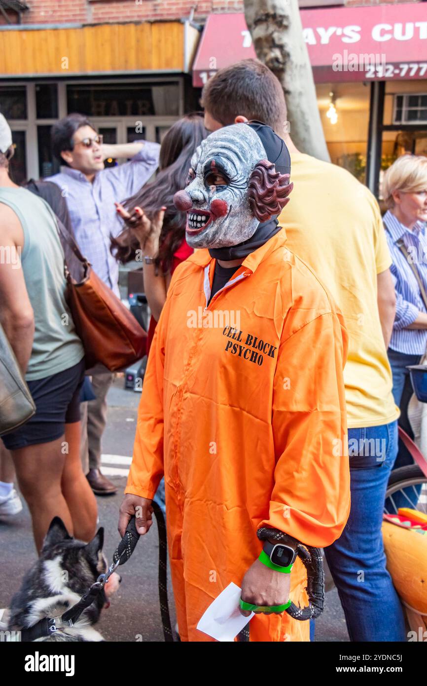 Personne dans un masque de clown effrayant se tient dans une rue animée de New york pendant un festival ou une parade de chien avec des gens en arrière-plan Banque D'Images