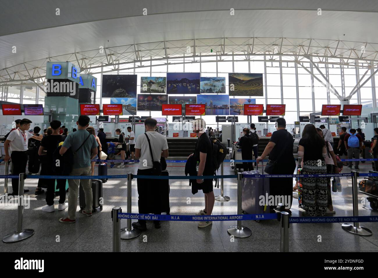 Hanoi, Vietnam - 26 juillet 2023 : les passagers font la queue aux comptoirs d'enregistrement de VietJet Airlines à l'aéroport international de Noi Bai, Han. Banque D'Images