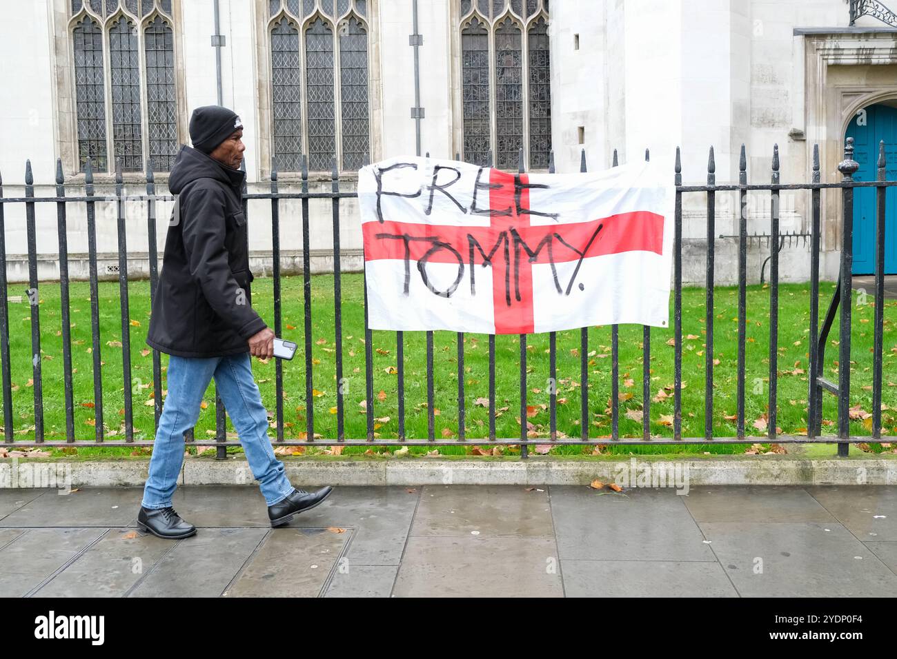 Un homme passe devant un drapeau de St George sur une rampe marquée avec les mots "Free Tommy" après une manifestation de Westminster appelée par l'activiste d'extrême droite. Banque D'Images Un homme passe devant un drapeau de St George sur une rampe marquée avec les mots "Free Tommy" après une manifestation de Westminster appelée par l'activiste d'extrême droite. Banque D'Images