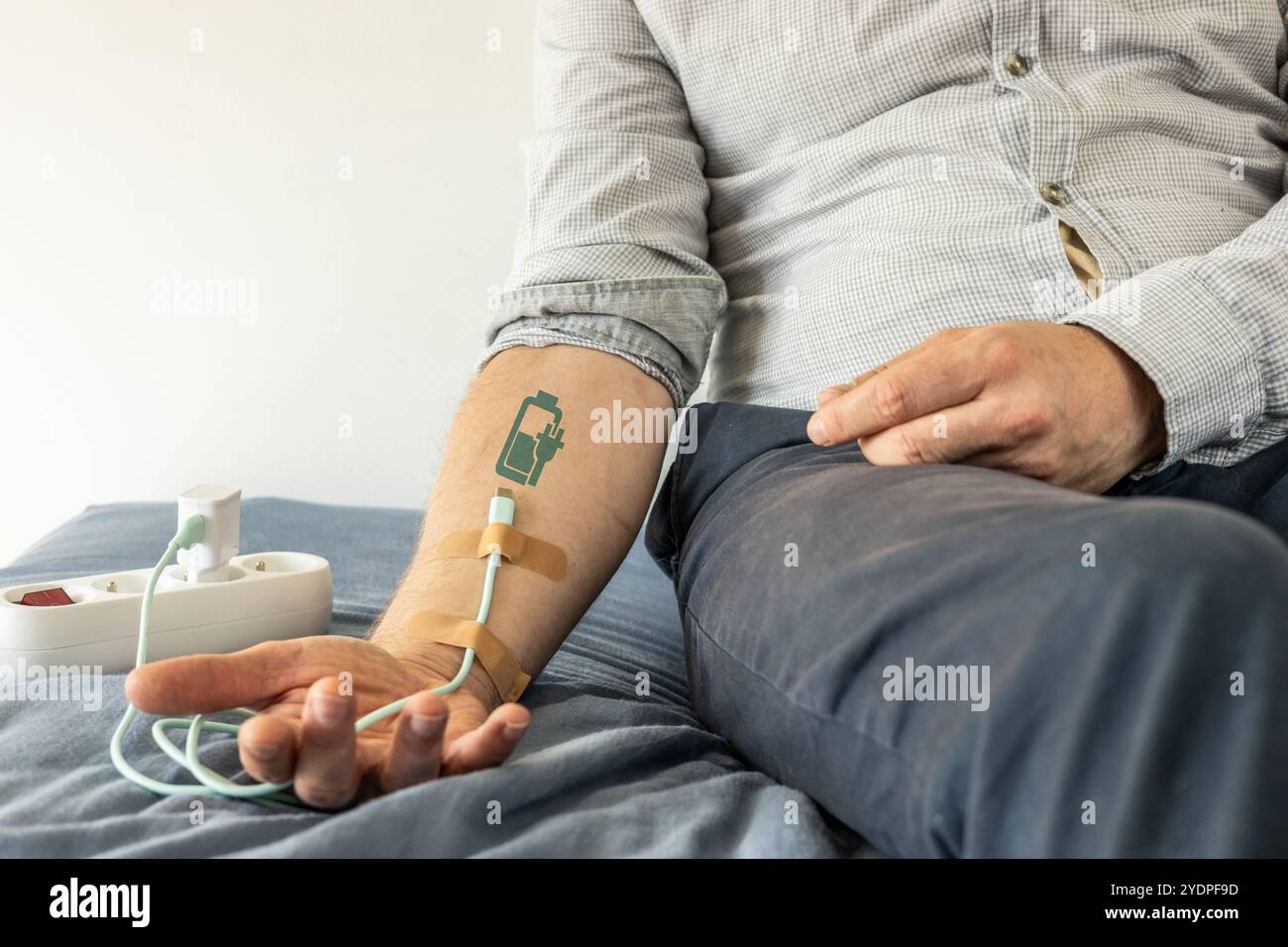 Câble de chargement USB connecté à la main comme un goutte à goutte. symbole de charge de la batterie. Fatigue, recharge, vitalité, pression, surmenage, endurance, fatigue, bu Banque D'Images