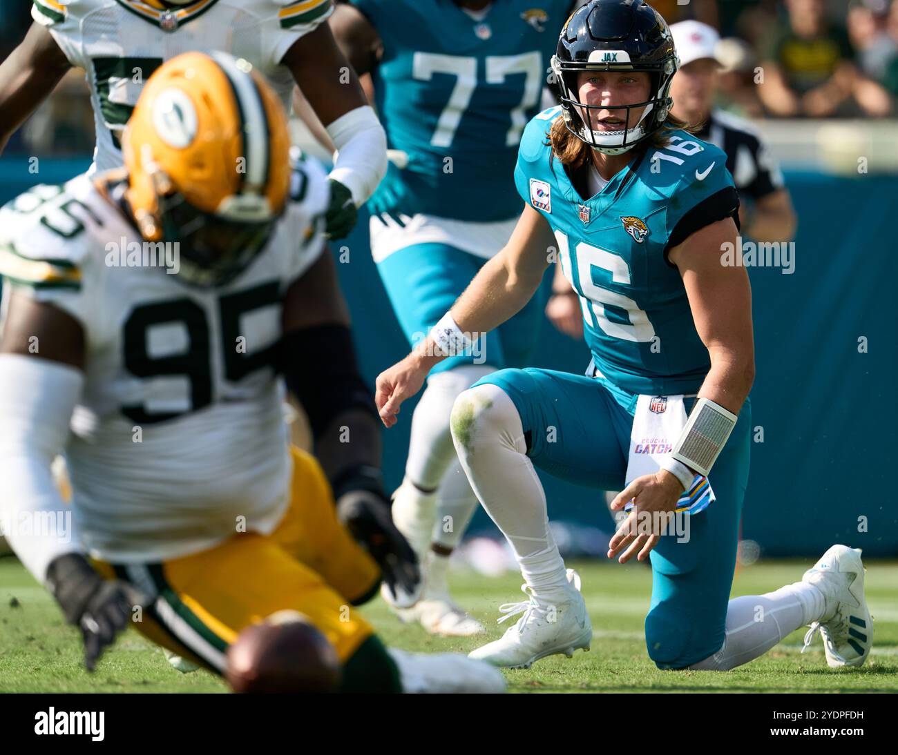 Jacksonville, Floride, États-Unis. 27 octobre 2024. National Football League, Jacksonville Jaguars vs Green Bay Packers. Le quarterback des Jaguars de Jacksonville, Trevor Lawrence (16 ans), regarde impuissant son fumble récupéré par le lineman défensif Devonte Wyatt (95 ans). Crédit photo : Tim Davis/Alamy Live News Banque D'Images