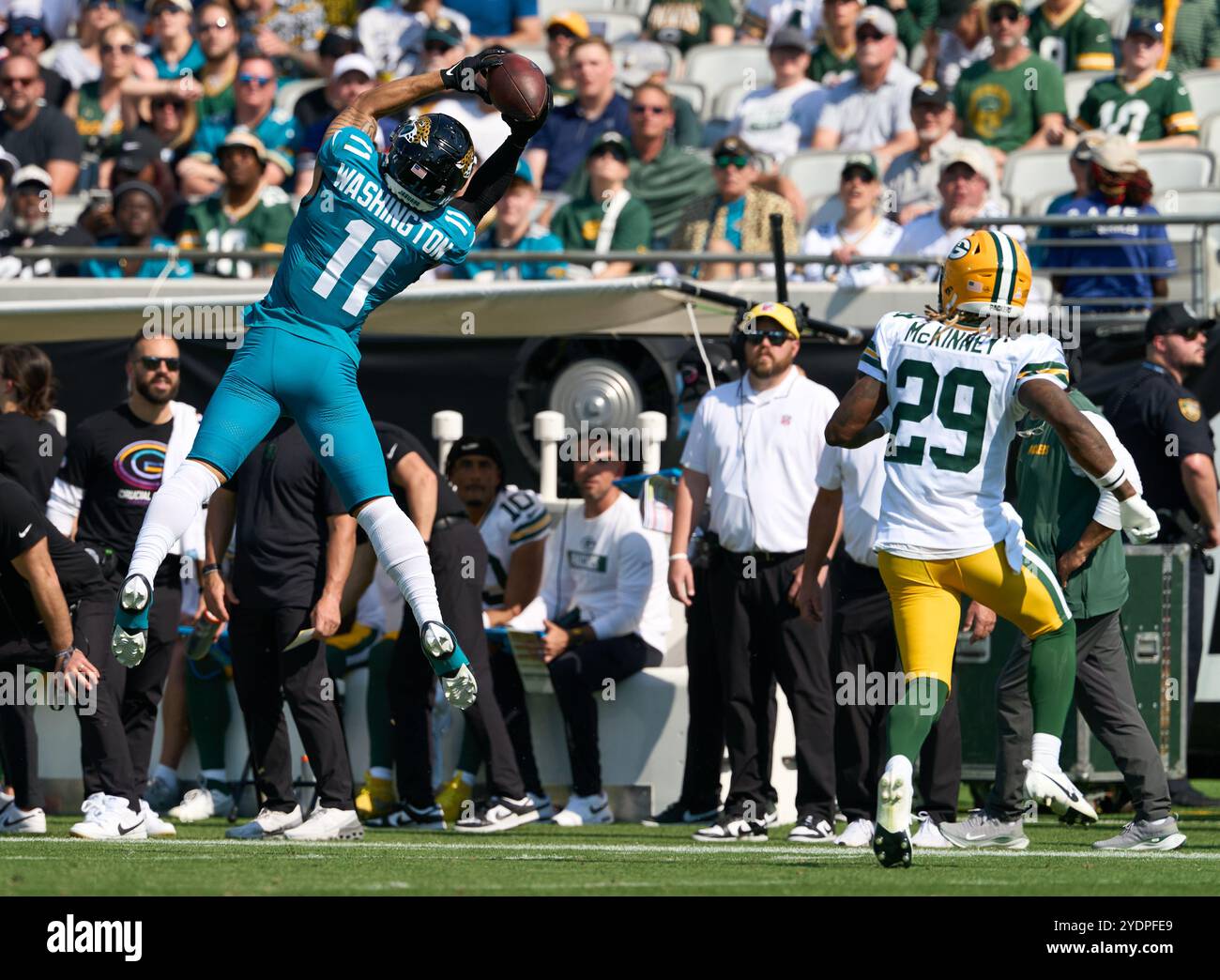Jacksonville, Floride, États-Unis. 27 octobre 2024. National Football League, Jacksonville Jaguars vs Green Bay Packers. Jacksonville Jaguars Wide Receiver Parker Washington (11 ans) fait une prise bondissante sur la ligne de touche alors qu'il est vaguement gardé par la sécurité des Packers de Green Bay Xavier McKinney (29 ans). Crédit photo : Tim Davis/Alamy Live News Banque D'Images