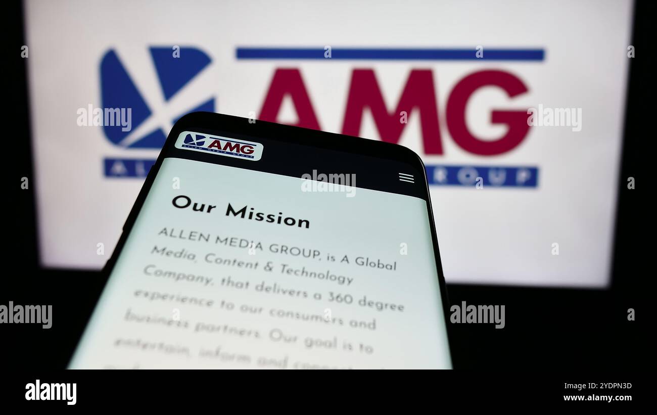 Dans cette illustration photo, un smartphone avec le site Web de la société de radiodiffusion américaine Allen Media Group (AMG) est vu devant le logo de l'entreprise. Banque D'Images