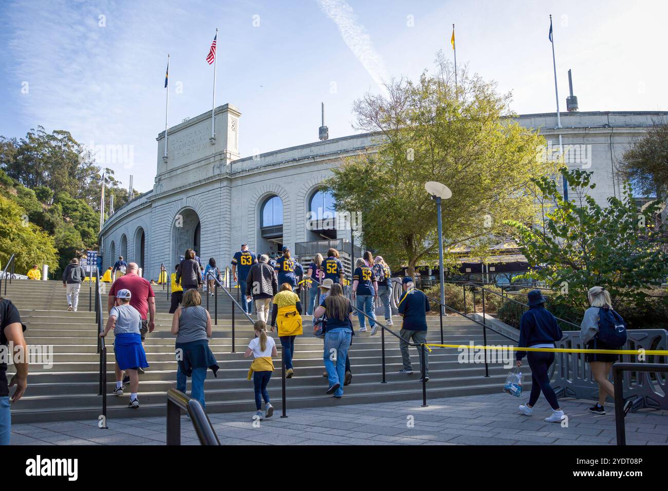 Les fans vêtus de bleu et d'or approchent du Memorial Stadium sur le campus de l'Université de Berkeley pour assister à un match de football des Cal Bears. Banque D'Images