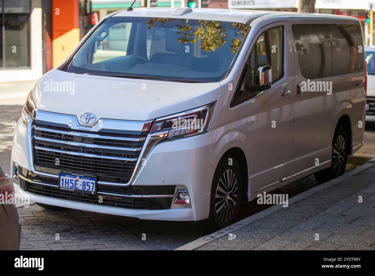 Une Toyota Granvia blanche stationnée dans une rue de la ville, arborant ses feux arrière distinctifs et ses accents chromés. Banque D'Images