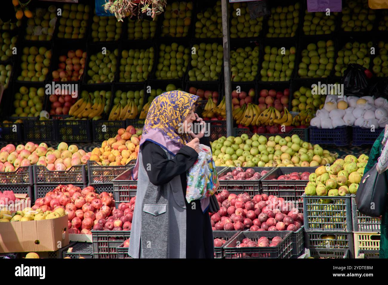 Tachkent, Ouzbékistan;septembre,16,2024:une femme musulmane âgée portant un hijab traditionnel est capturée parlant sur son téléphone alors qu'elle marchait Banque D'Images