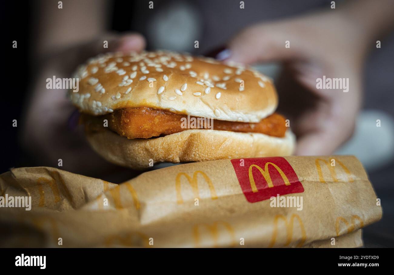 Une femme montre un hamburger McDonald's le 26 octobre 2024 à Guwahati, en Inde. Les récents problèmes de sécurité alimentaire de McDonald's causant une baisse de stock de 5 %, après e-coli c Banque D'Images