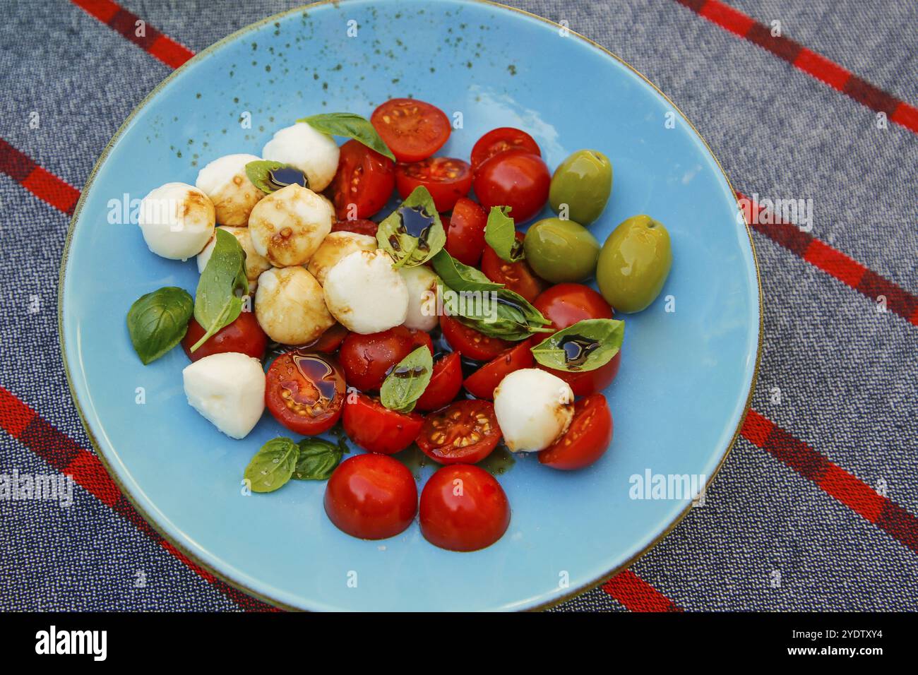 Cuisine italienne, cuisine méditerranéenne, mozzarella, basilic, tomates cerises, tomates cocktail, caprese avec mini tomates, olives vertes, assiette, salade Banque D'Images