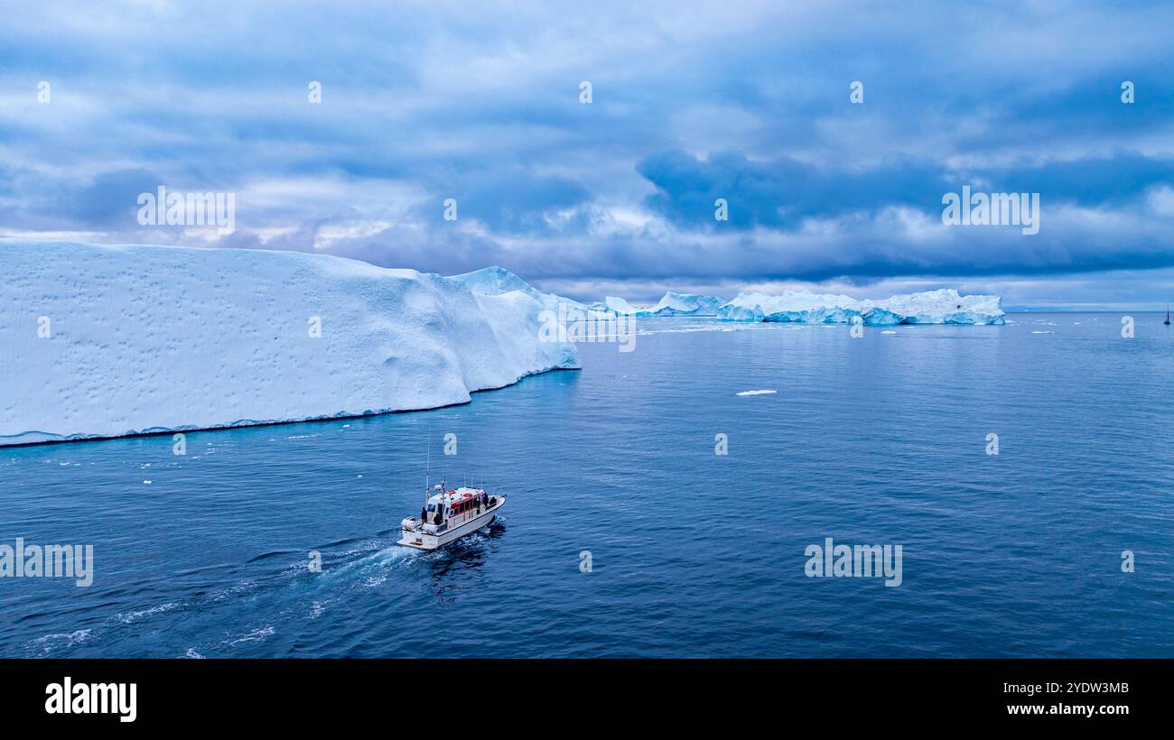 Aérien d'un bateau entre les icebergs du fjord glacé d'Ilulissat, site du patrimoine mondial de l'UNESCO, Groenland occidental, Danemark, régions polaires Banque D'Images