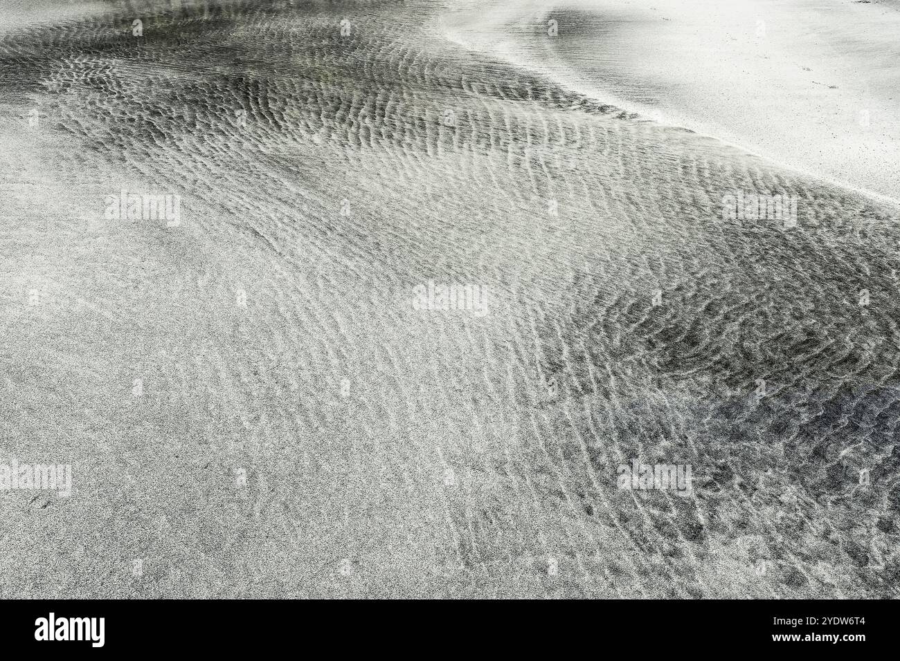 Tri par marée du sable blanc et des minéraux plus sombres en motifs sur la plage de la côte ouest de Talisker Bay, Skye, Écosse Banque D'Images