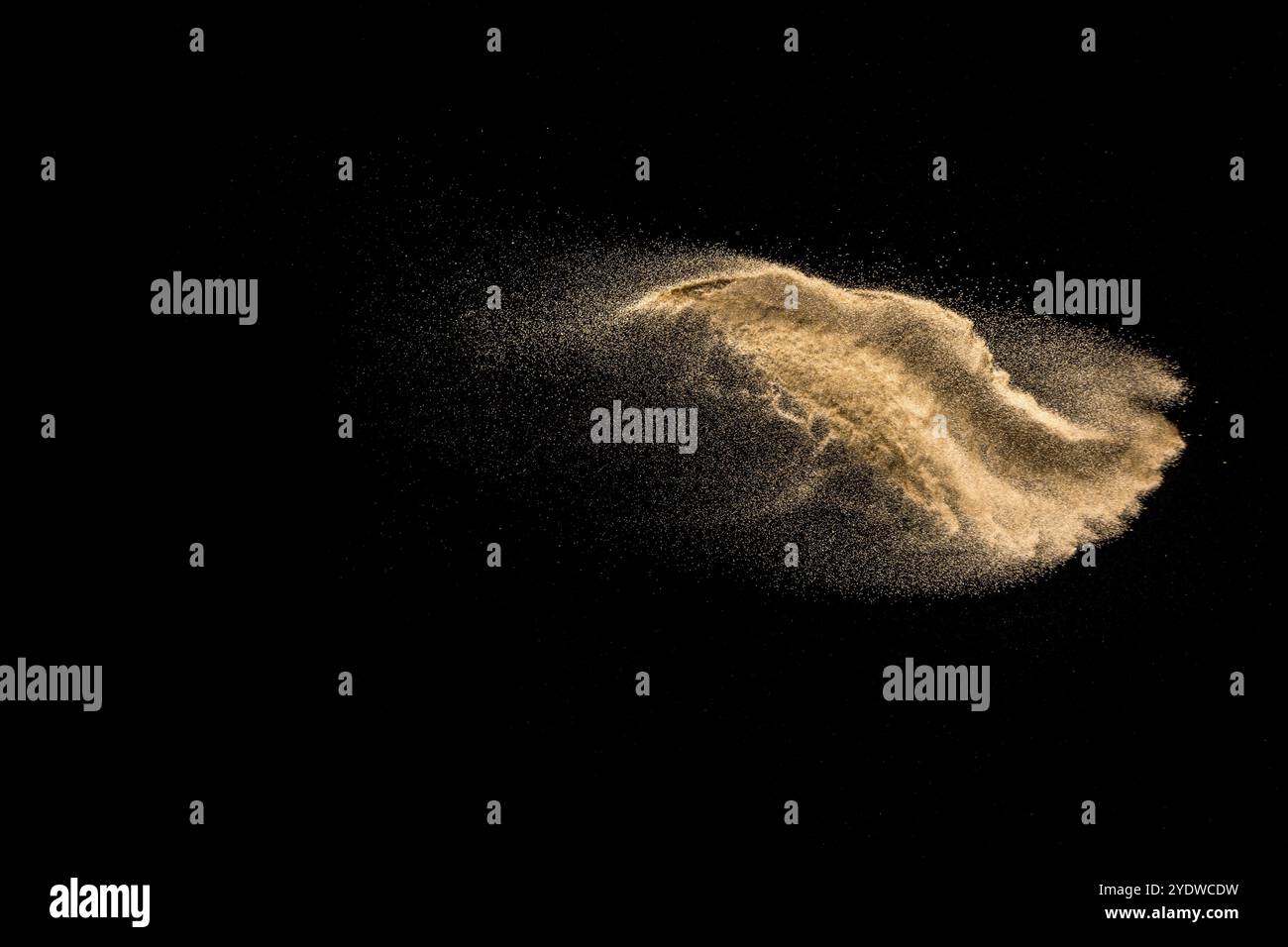 Explosion de sable doré isolé sur fond noir. Nuage de sable résumé. De couleur sable doré splash sur un fond sombre. Sable jaune voler dans l'ONDE T Banque D'Images