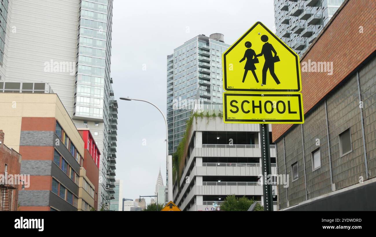 Panneau routier jaune de la zone scolaire, passage piéton. Sécurité des enfants, New York City Street. Symbole du transport et de l'éducation, États-Unis. Panneau de signalisation, Queens, long Island. Vue sur Manhattan, Chrysler Building. Banque D'Images