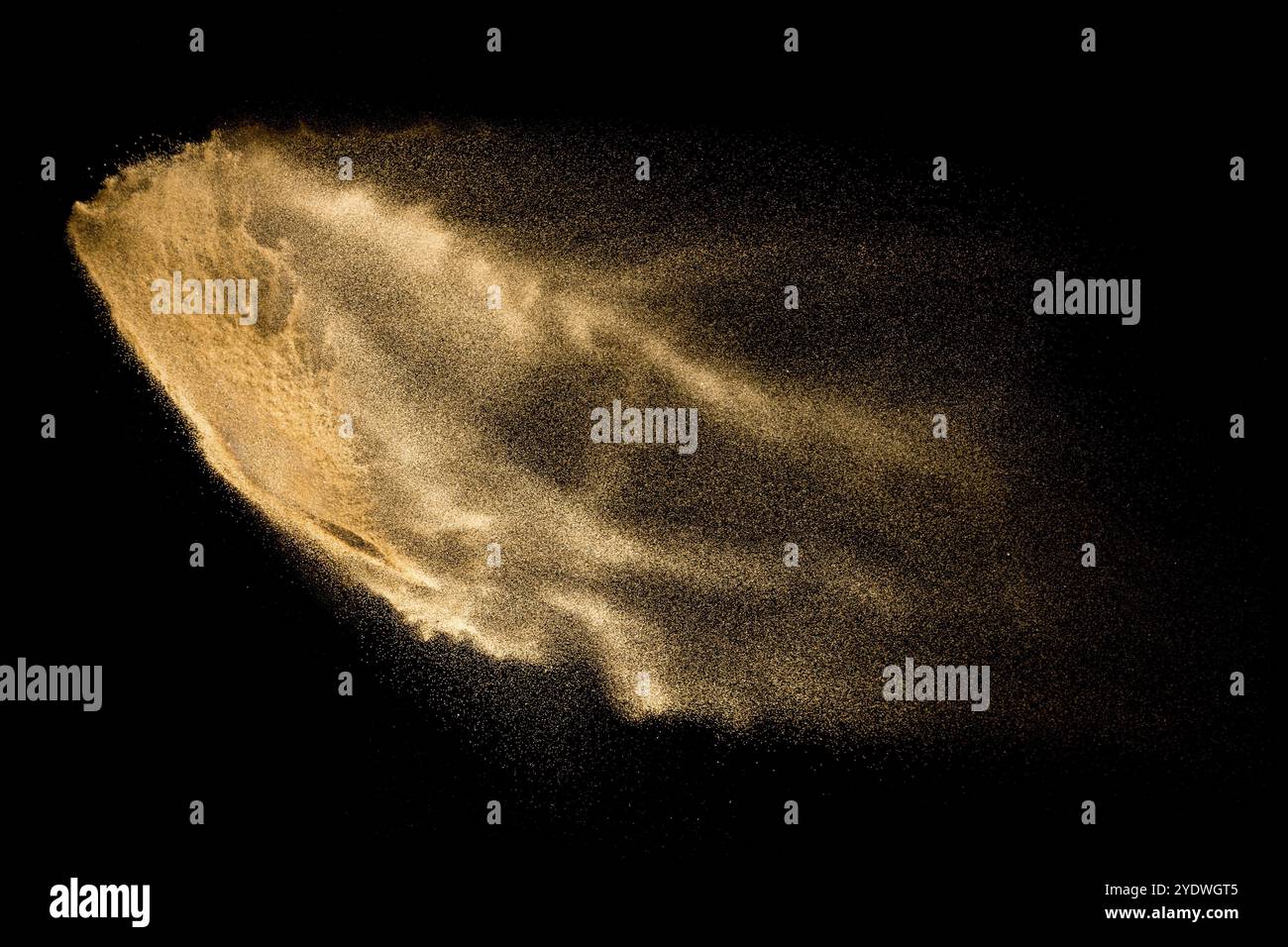 Explosion de sable jaune isolée sur fond noir. Nuage de sable abstrait Banque D'Images