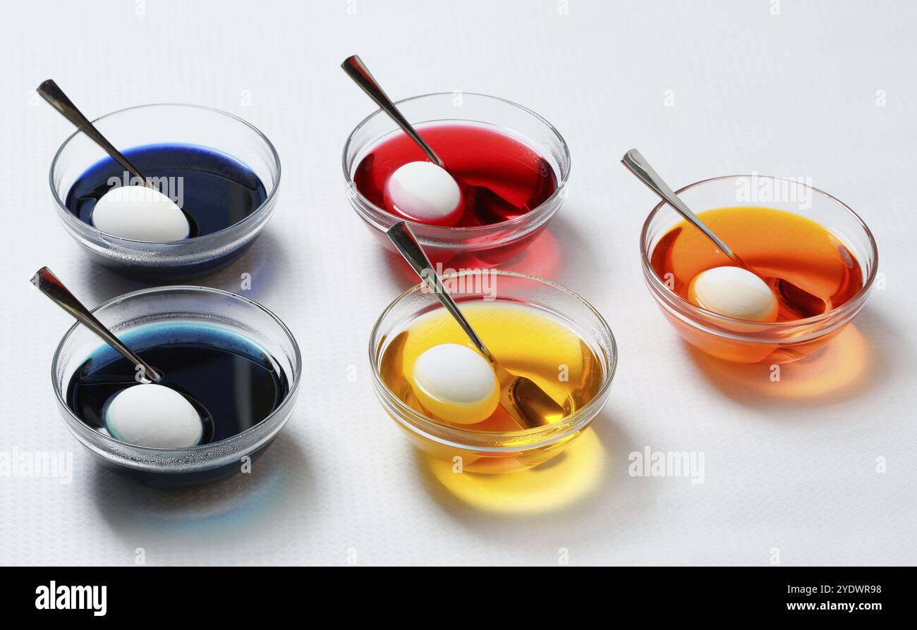 Cinq bols avec des oeufs dans des teintures de différentes couleurs Banque D'Images