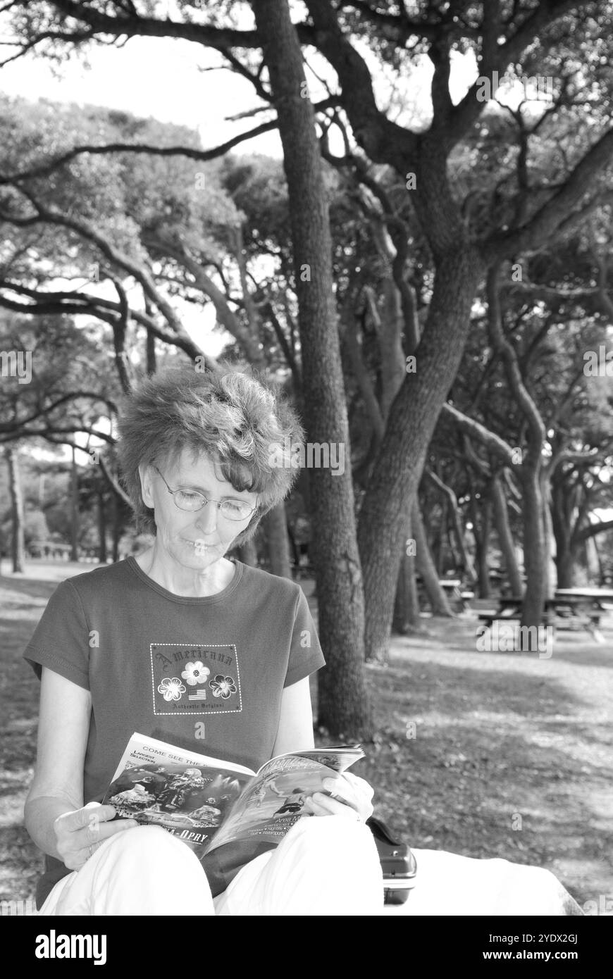 Femme âgée caucasienne, de 50 à 55 ans, lisant une brochure de voyage tout en se relaxant au Myrtle Beach State Park, Caroline du Sud, États-Unis. Banque D'Images