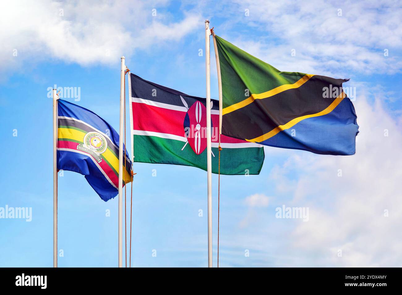 EAC, drapeau de la Communauté de l'Afrique de l'est, drapeaux du Kenya et de la Tanzanie sur un ciel bleu nuageux Banque D'Images
