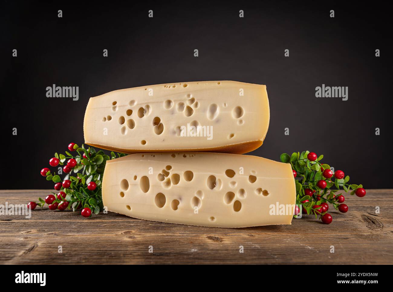 Deux morceaux de fromage suisse reposant sur une surface en bois rustique Banque D'Images