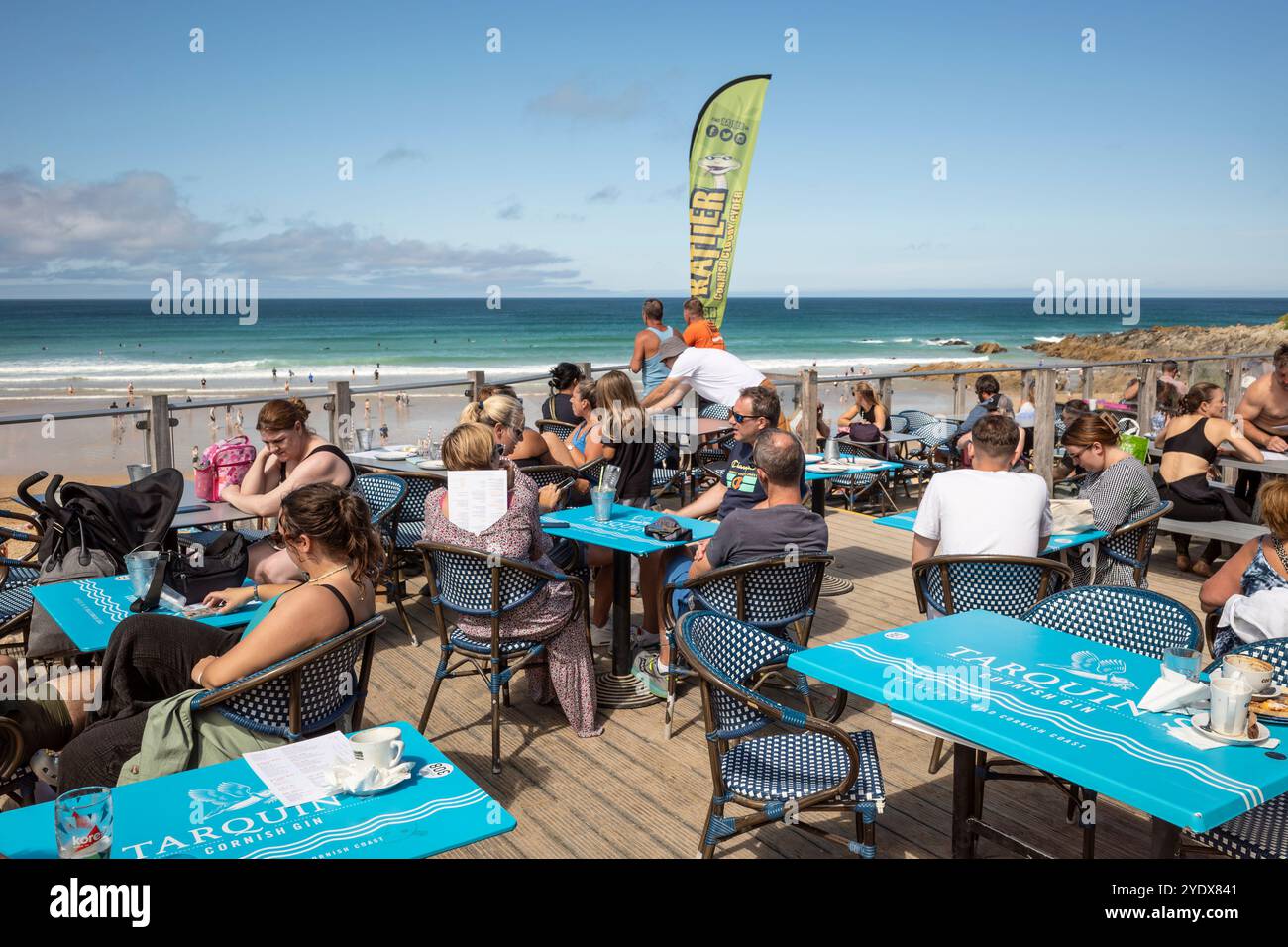 Vacanciers appréciant le soleil d'été assis sur la terrasse extérieure du bar Fistral Beach à Newquay en Cornouailles au Royaume-Uni. Banque D'Images