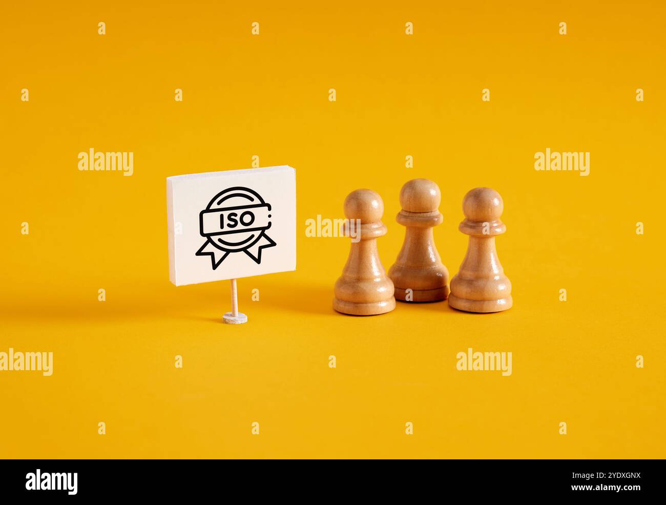 Certification ISO. Présentation de l'obtention du certificat ISO lors d'une réunion d'affaires. Pions d'échecs près d'une bannière avec l'organisation internationale iso pour s. Banque D'Images