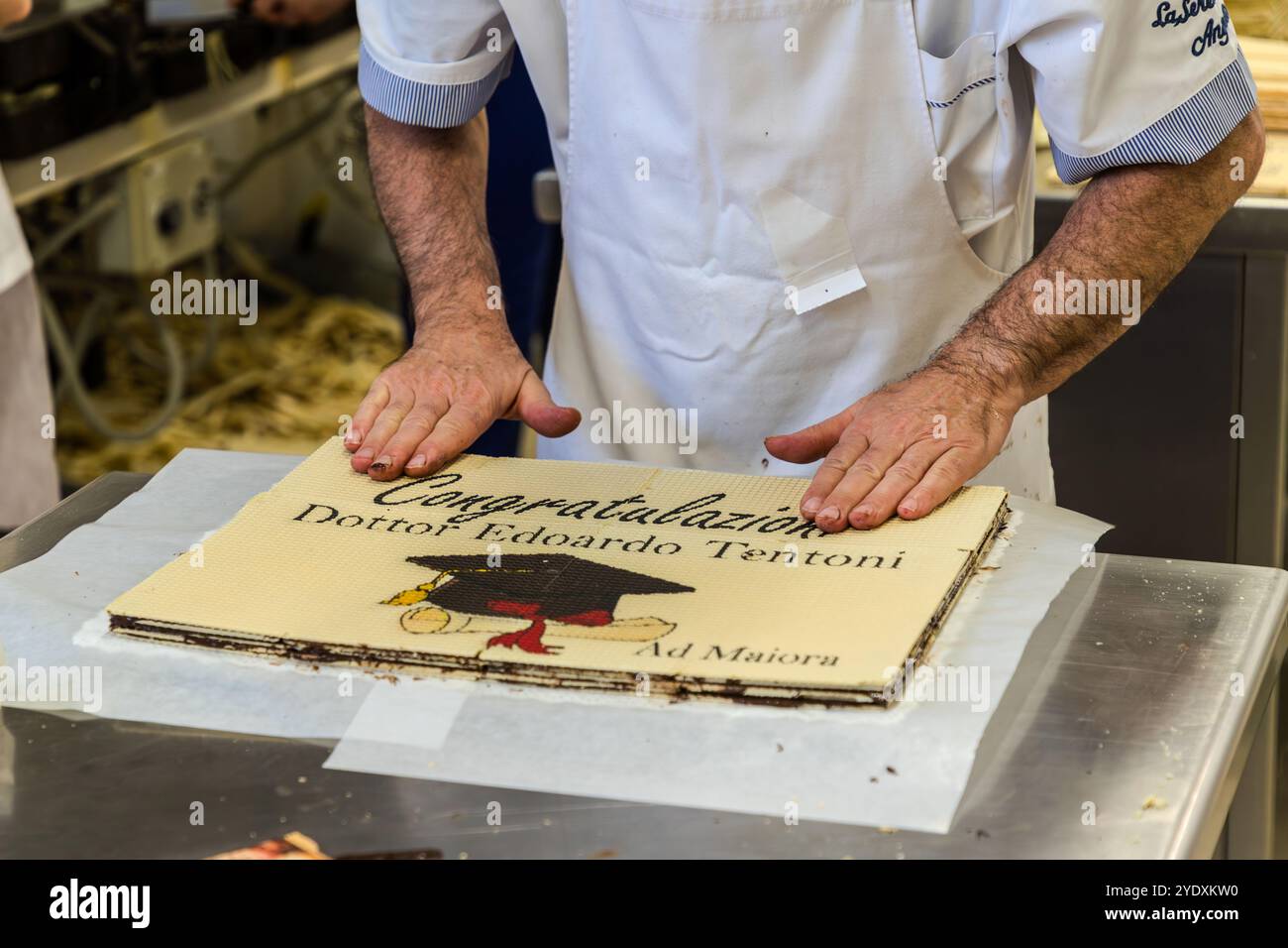 La nouvelle tendance autour de la traditionnelle Torta Tre Monti est le gâteau de gaufrette personnalisé : une imprimante laser imprime la gaufrette avec des motifs photo ou des logos. Les occasions sont des anniversaires, des mariages ou des diplômes universitaires. Un gaufrier de la Serenissima décore une gaufre avec le message de félicitations : « Félicitations, docteur Eduardo Tentoni » et le prédicat « ad Maiora ». Via XXV Marzo, Domagnano, Saint-Marin Banque D'Images