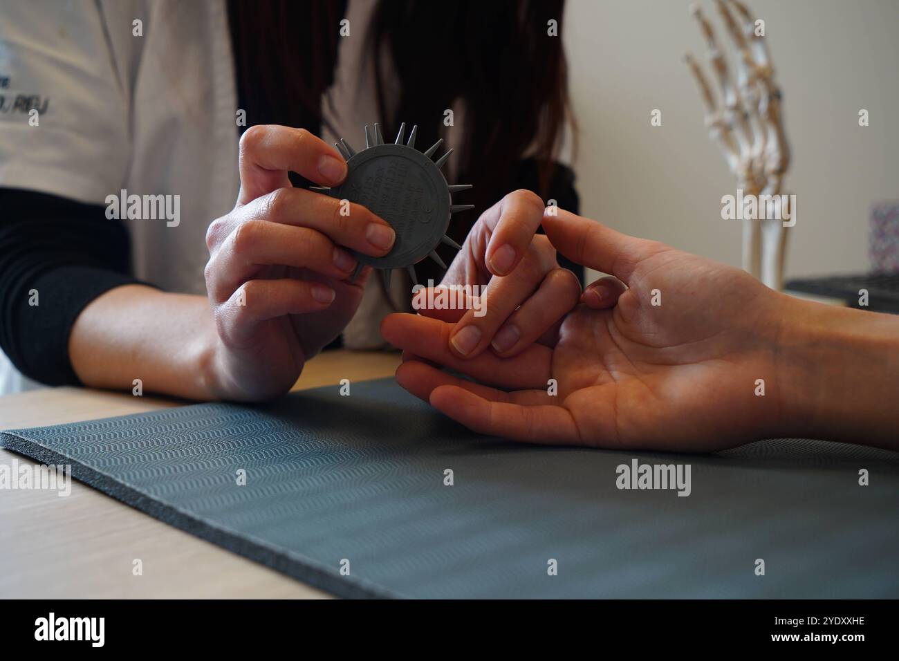 Centre de physiothérapie spécialisé dans les pathologies de la main, du coude et de l'épaule avant ou après l'opération. Test de Weber, discrimination tactile. Physiothérapie Banque D'Images