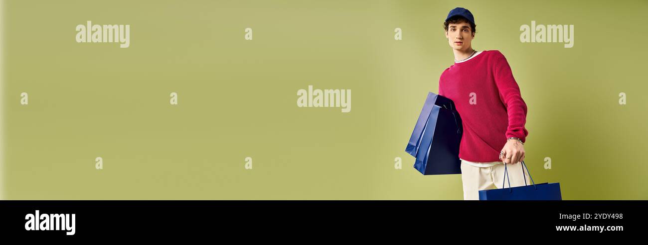 Un jeune homme à la mode avec des boucles célèbre le Black Friday tout en tenant des sacs à provisions colorés dans une toile de fond de studio. Banque D'Images
