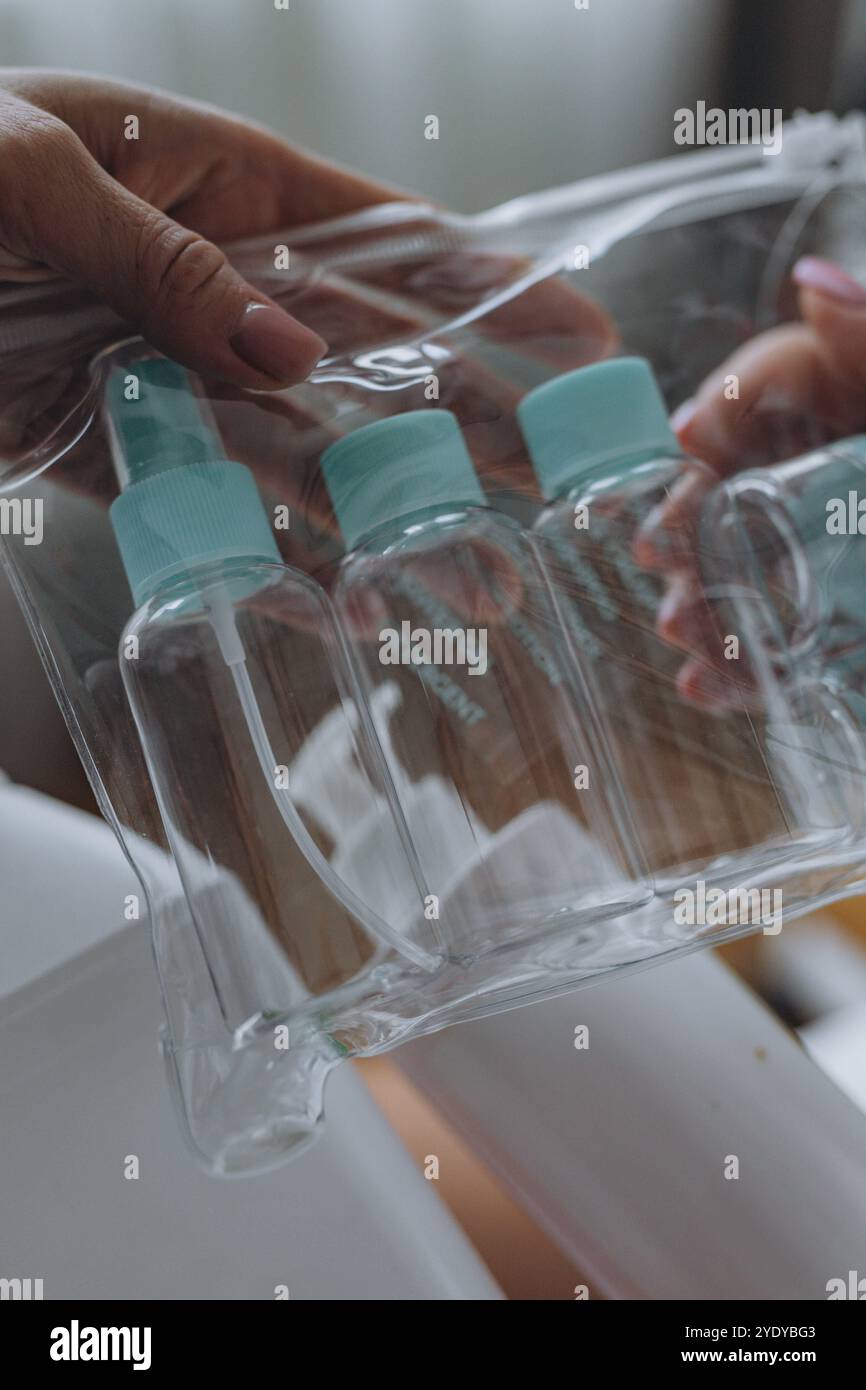 Cosmétologue montre au client un produit cosmétique et une bouteille de voyage. Photo de haute qualité Banque D'Images