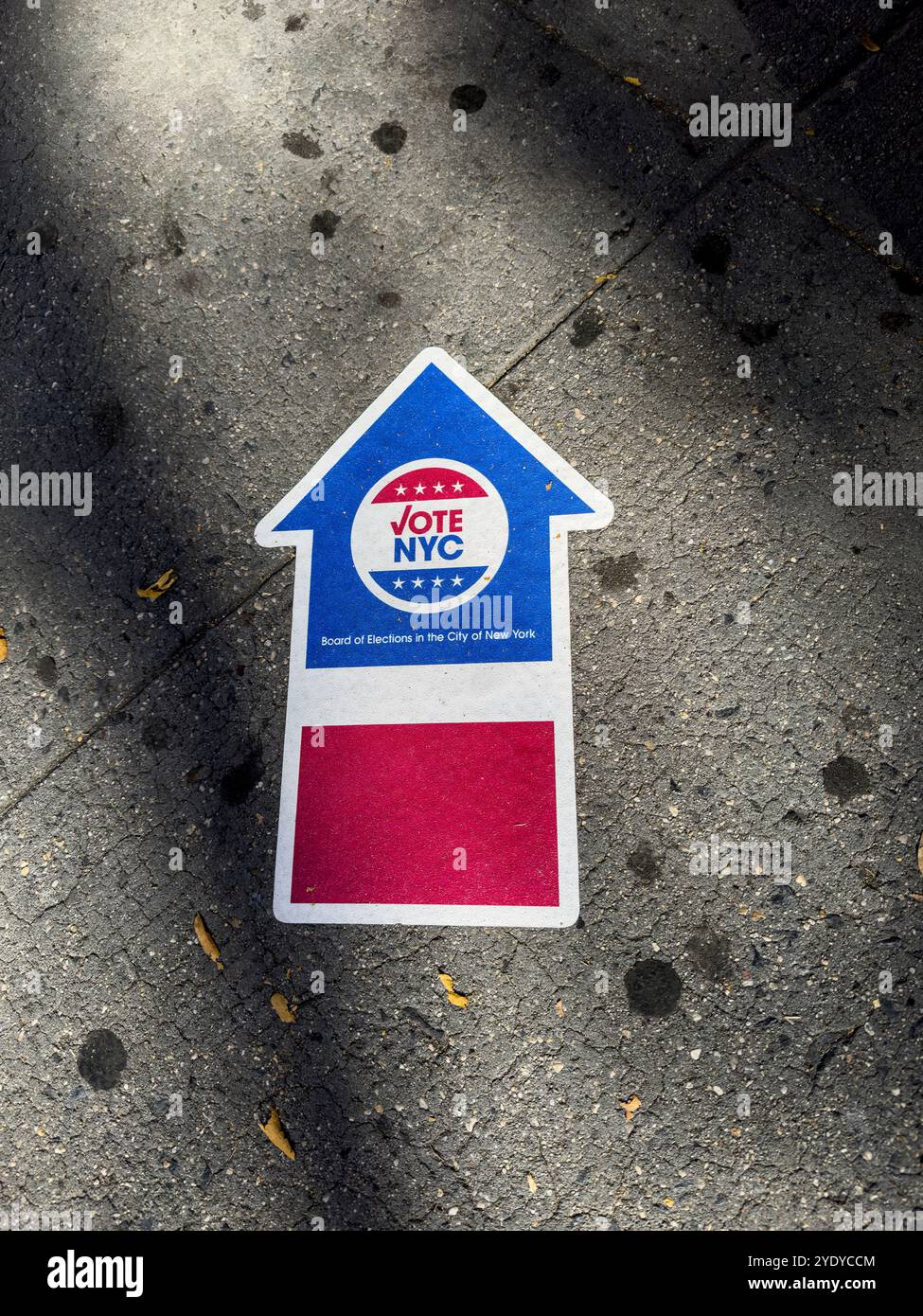 Flèche sur le trottoir indiquant le chemin vers un bureau de vote pour l'élection présidentielle de 2024 aux États-Unis d'Amérique, New York City, NY, US - Image de stock capturée avec un smartphone