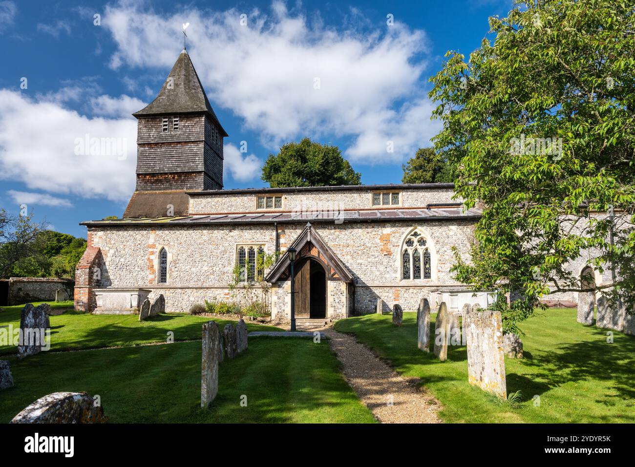 Le soleil brille sur l'église paroissiale en silex et en galets de St Peter à Hurstbourne Tarrant, Hampshire. Banque D'Images
