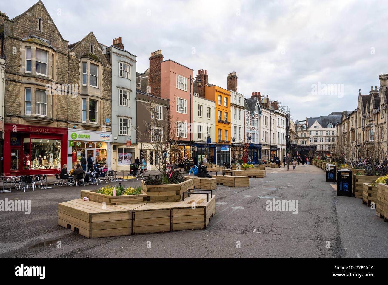 Les piétons et les acheteurs profitent de sièges temporaires aménagés dans la chaussée lors d'un essai de piétonisation de Broad Street dans le centre-ville d'Oxford. Banque D'Images