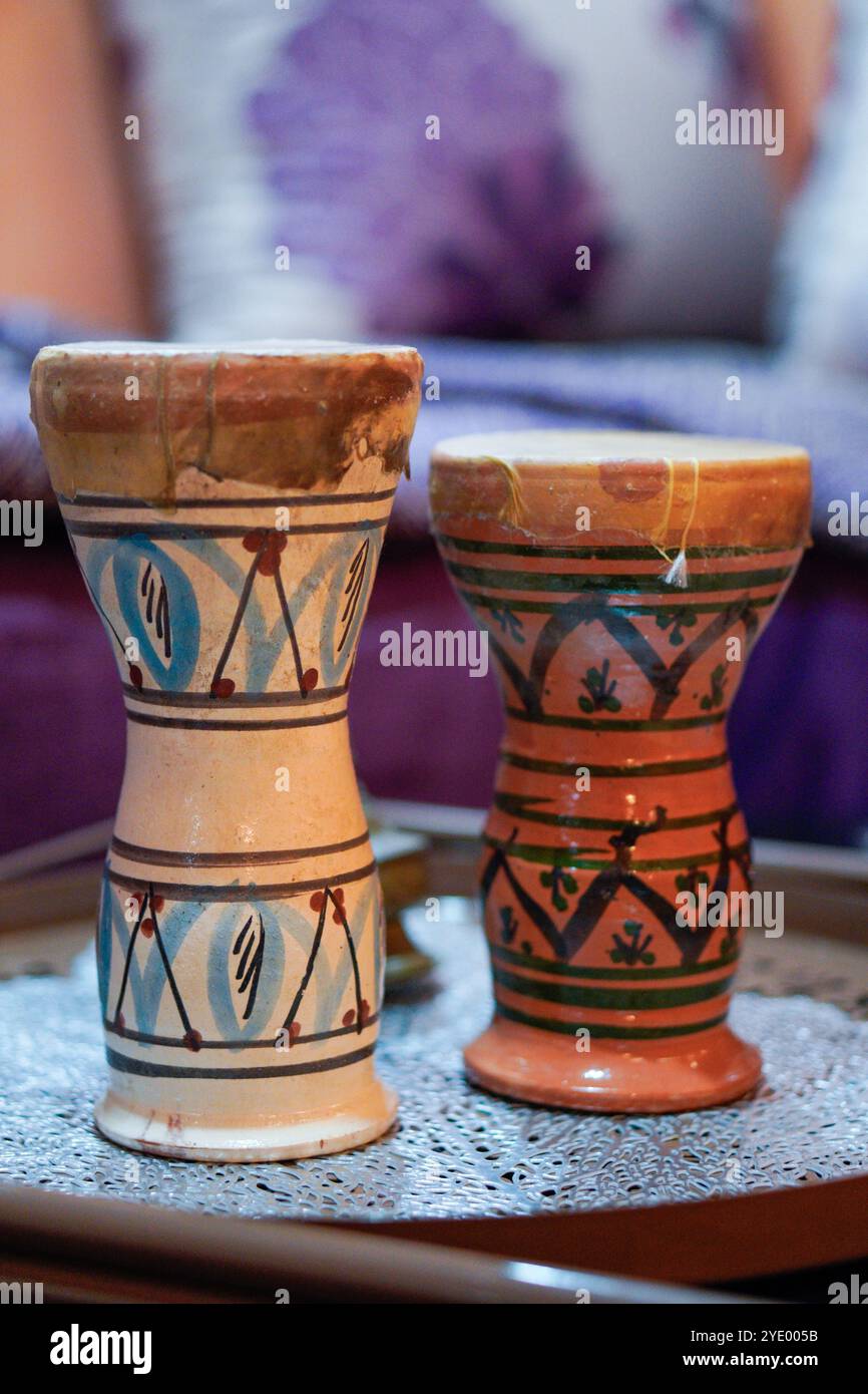 Deux instruments marocains traditionnels en céramique avec des motifs complexes peints à la main. Les 'Taarija' sont placés sur un tapis décoratif en dentelle Banque D'Images