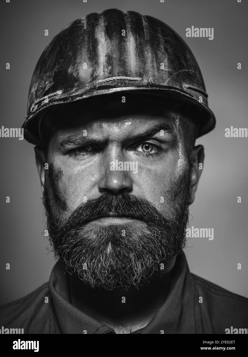 Homme bâtisseur. Gros plan portrait d'un constructeur masculin sérieux dans le casque de sécurité. Ouvrier de construction, ingénieur ou architecte en casque de protection. Mécanique barbu Banque D'Images