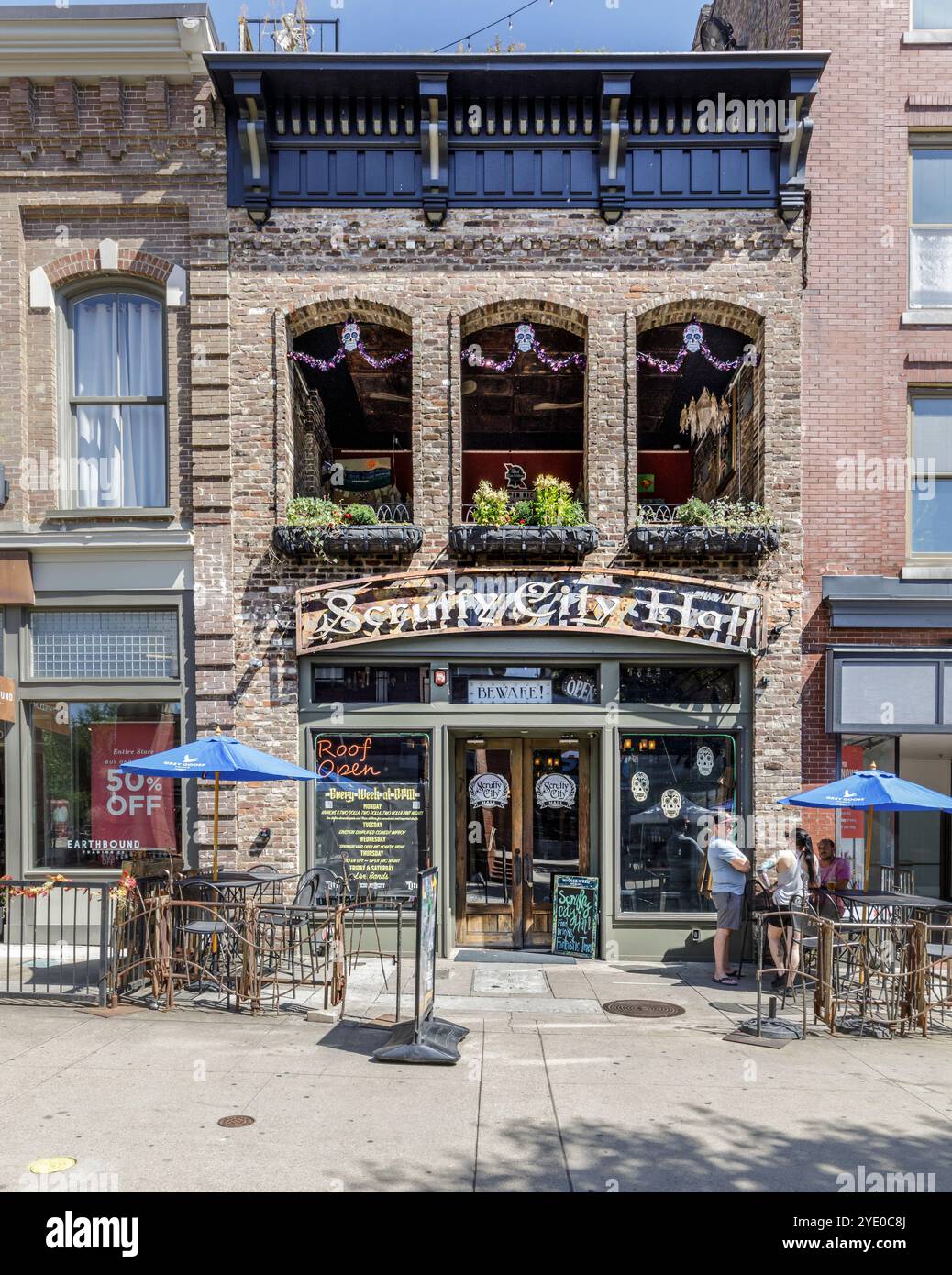 Knoxville, TN, USA-21 septembre 2024 : Scruffy City Hall bar et lieu de divertissement sur Market Square, 3 personnes parlant sur le trottoir à l'extérieur. Banque D'Images