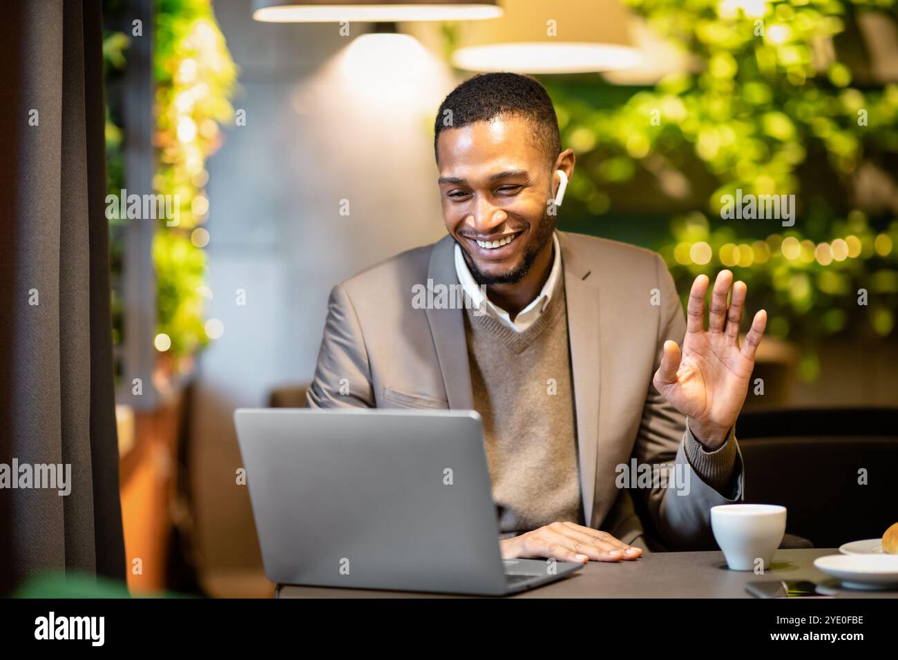 Homme d'affaires noir souriant faisant des appels vidéo à la famille Banque D'Images