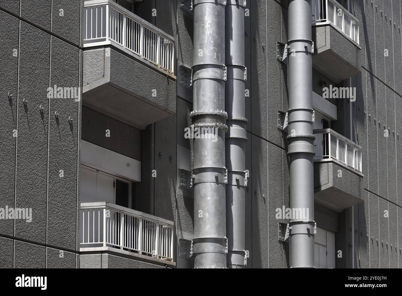 Une entrée de chargement équipée d'un balcon à chaque étage du bâtiment et une grande tuyauterie installée sur le mur Banque D'Images