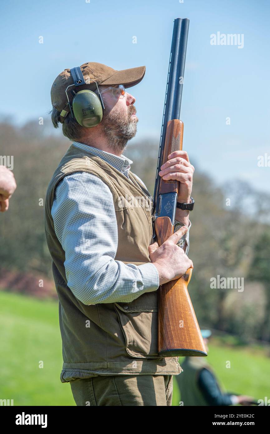 homme tenant un fusil de chasse avec protection auditive et lunettes de sécurité Banque D'Images