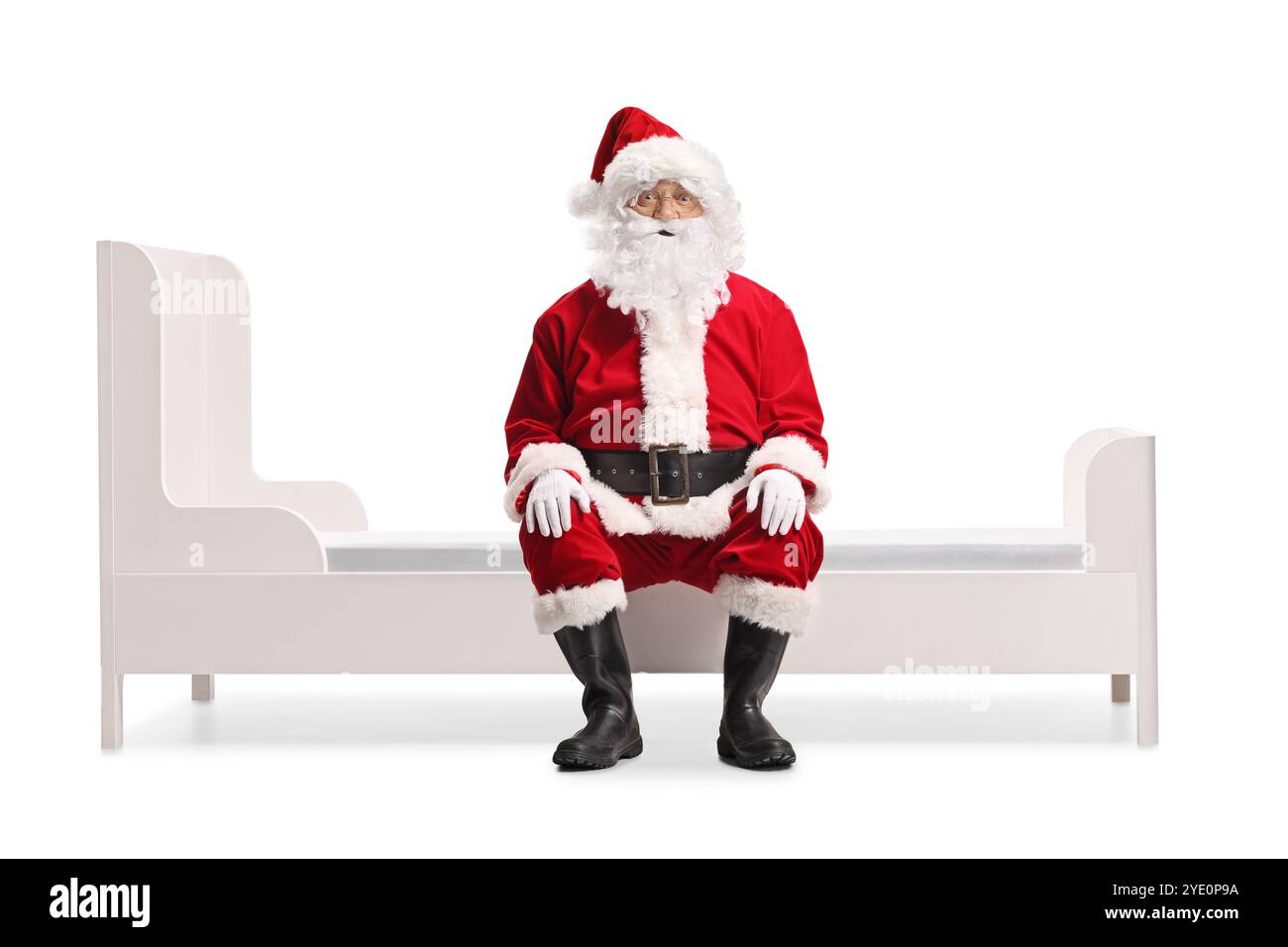 Le Père noël est assis sur un lit isolé sur fond blanc Banque D'Images