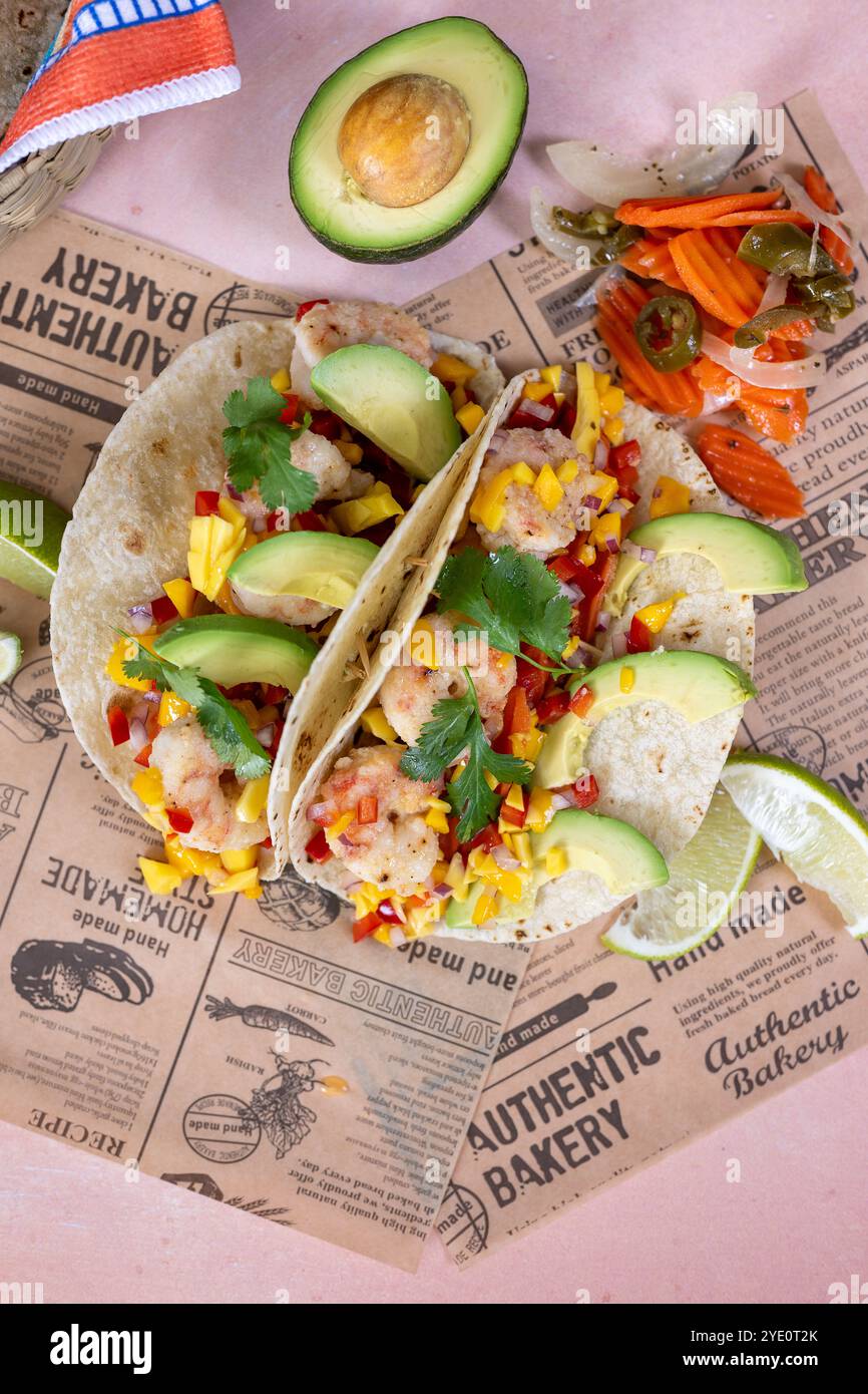 Crevettes Baja grillées sur tacos au maïs avec sauce salsa à la mangue et faux journal Banque D'Images