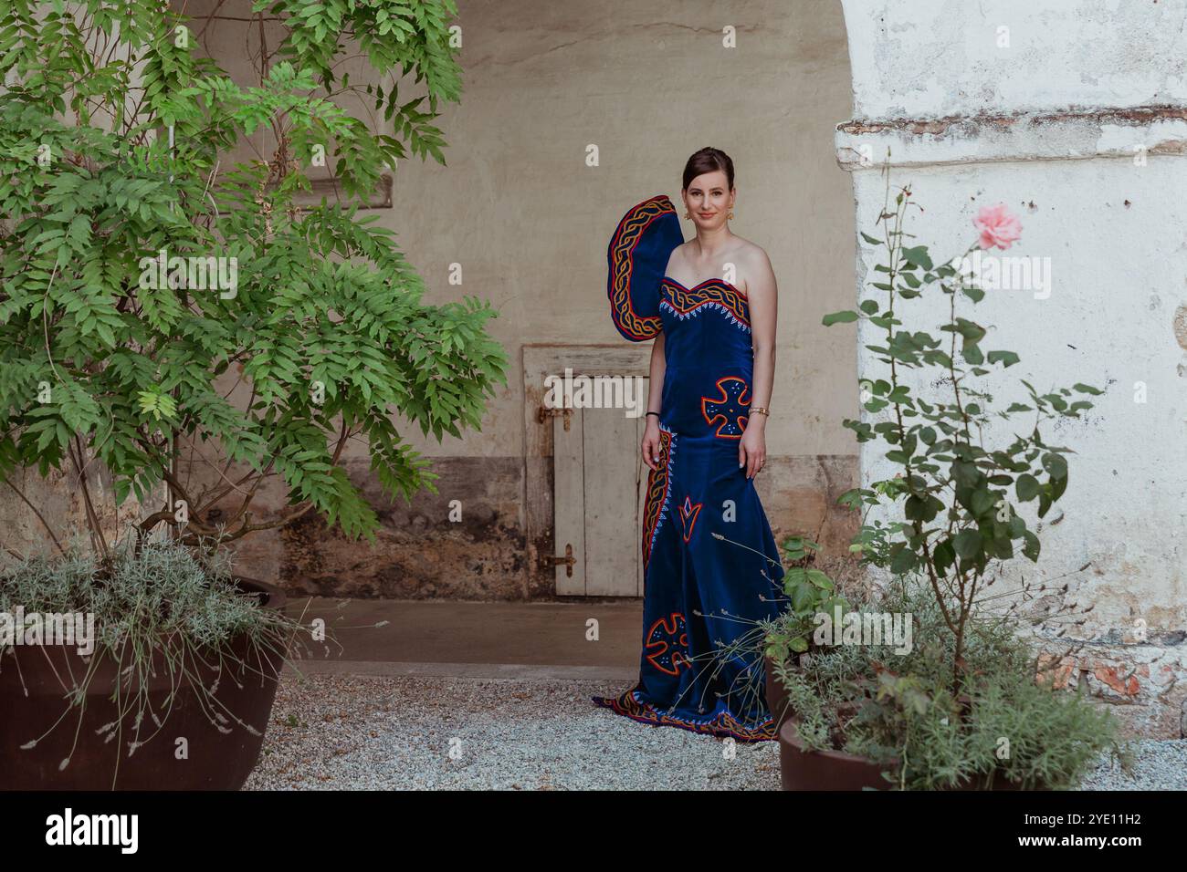 Jeune mariée en robe de mariée africaine traditionnelle posant par la colonne Banque D'Images