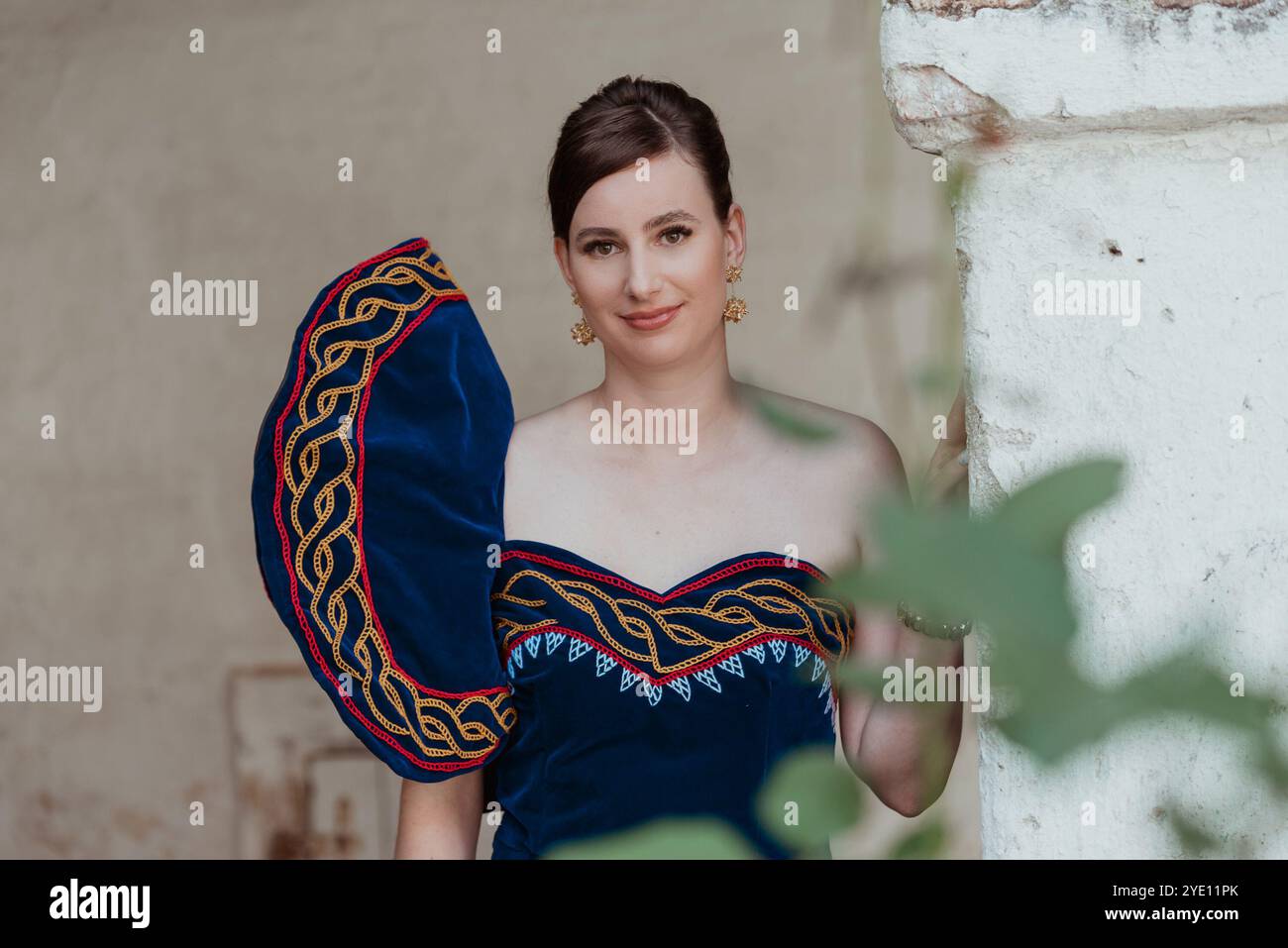 Jeune mariée en robe de mariée africaine traditionnelle posant par la colonne Banque D'Images