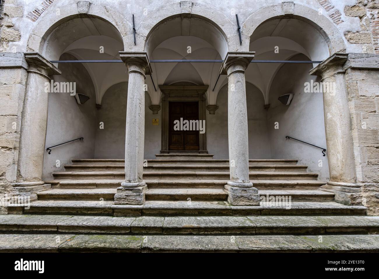 L’Université de la République de Saint-Marin a été fondée en 1985, issue de la Scuola Superiore di Studi Storici. Depuis une réorganisation en 2014, elle comprend trois facultés et est membre de l’Espace européen de l’enseignement supérieur. Une loggia avec des colonnes toscanes et un plafond voûté mène à l’entrée de l’un de ses bâtiments. Via Eugippo, Ville de Saint-Marin. Banque D'Images